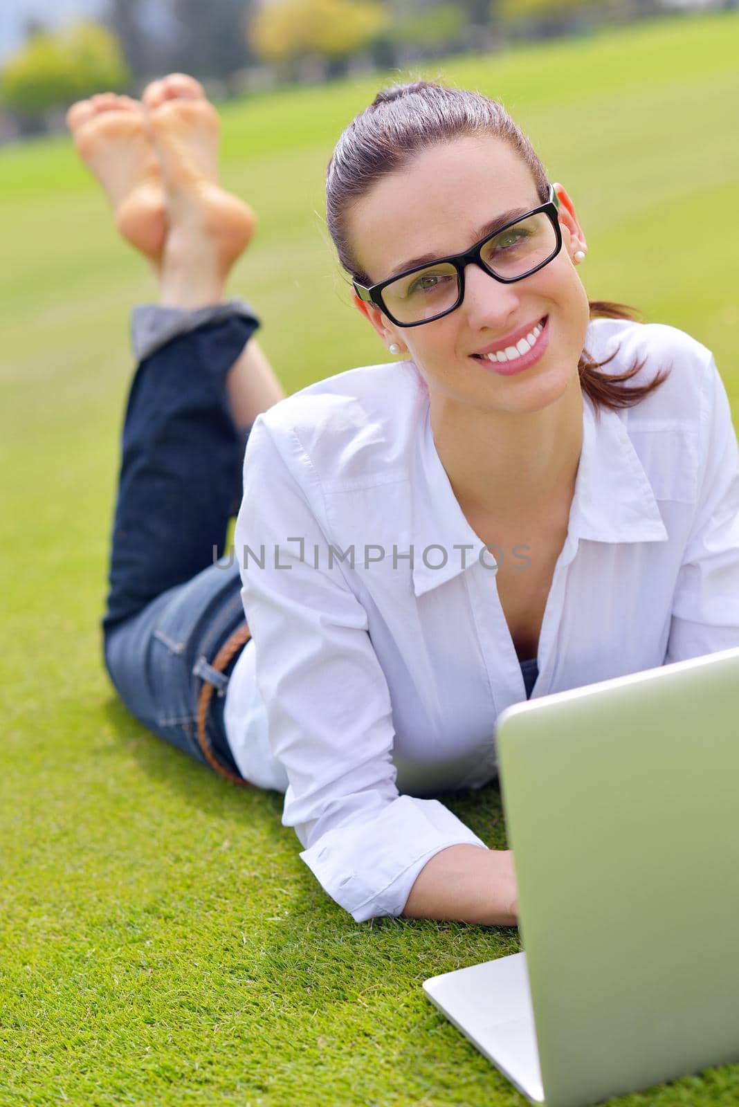 happy young student woman with laptop in city park study