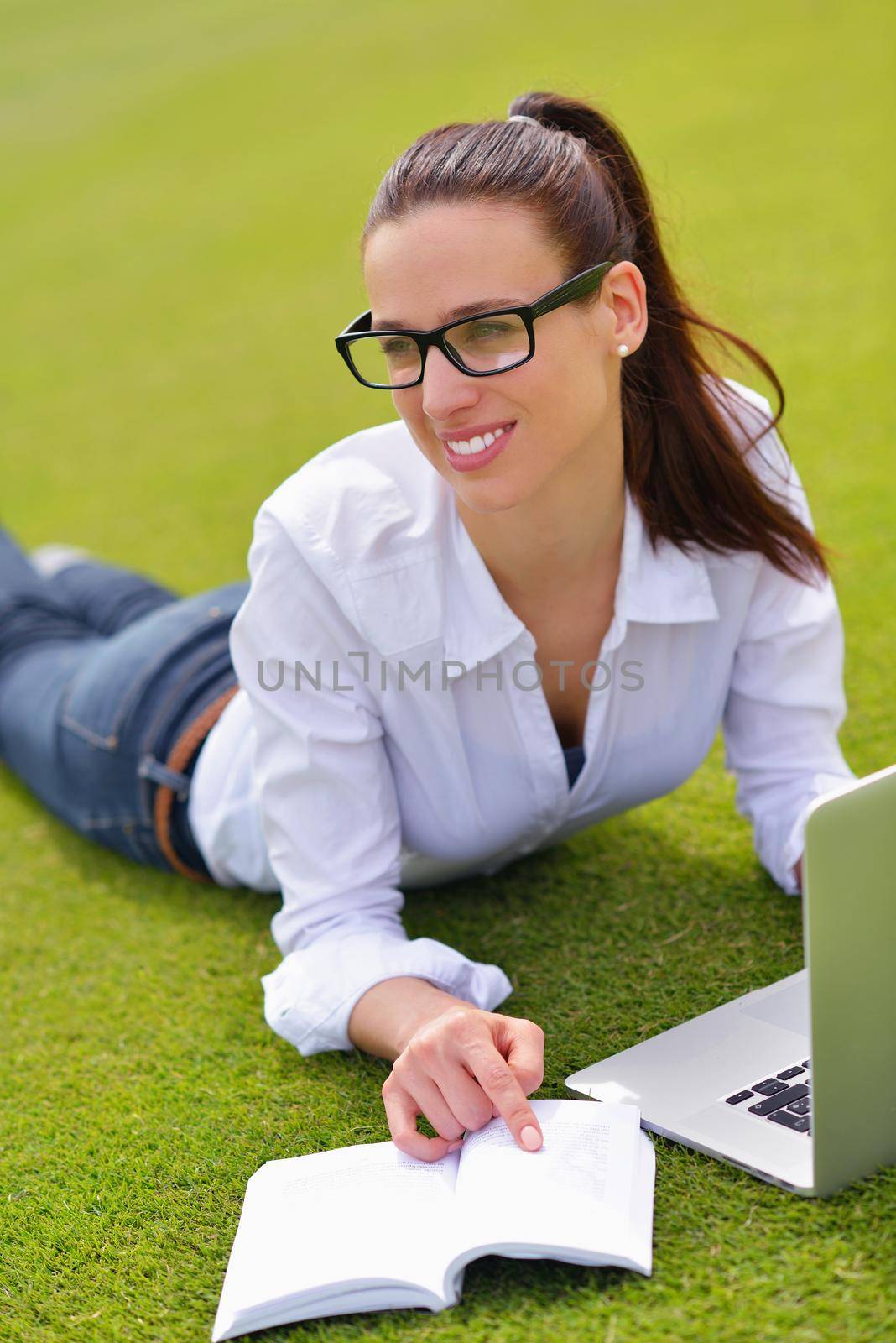 happy young student woman with laptop in city park study