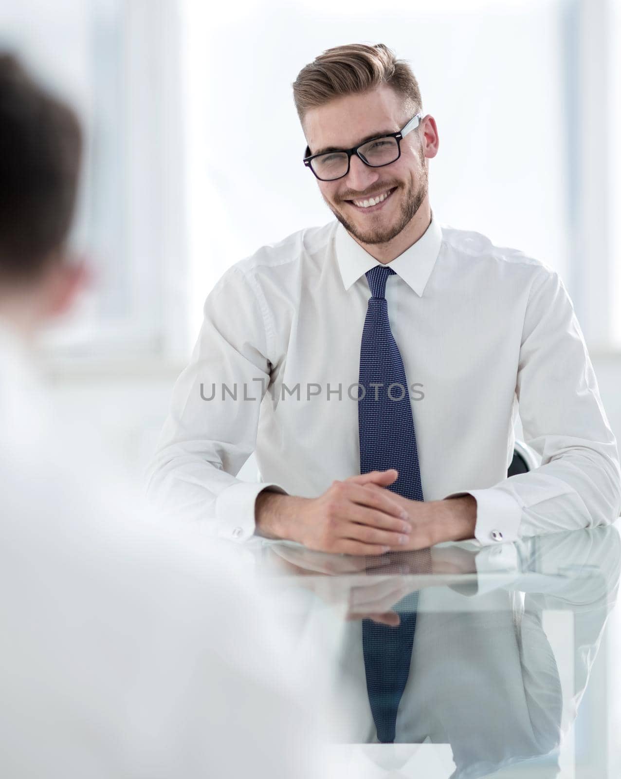 Manager talks to the employee sitting at his Desk.business concept