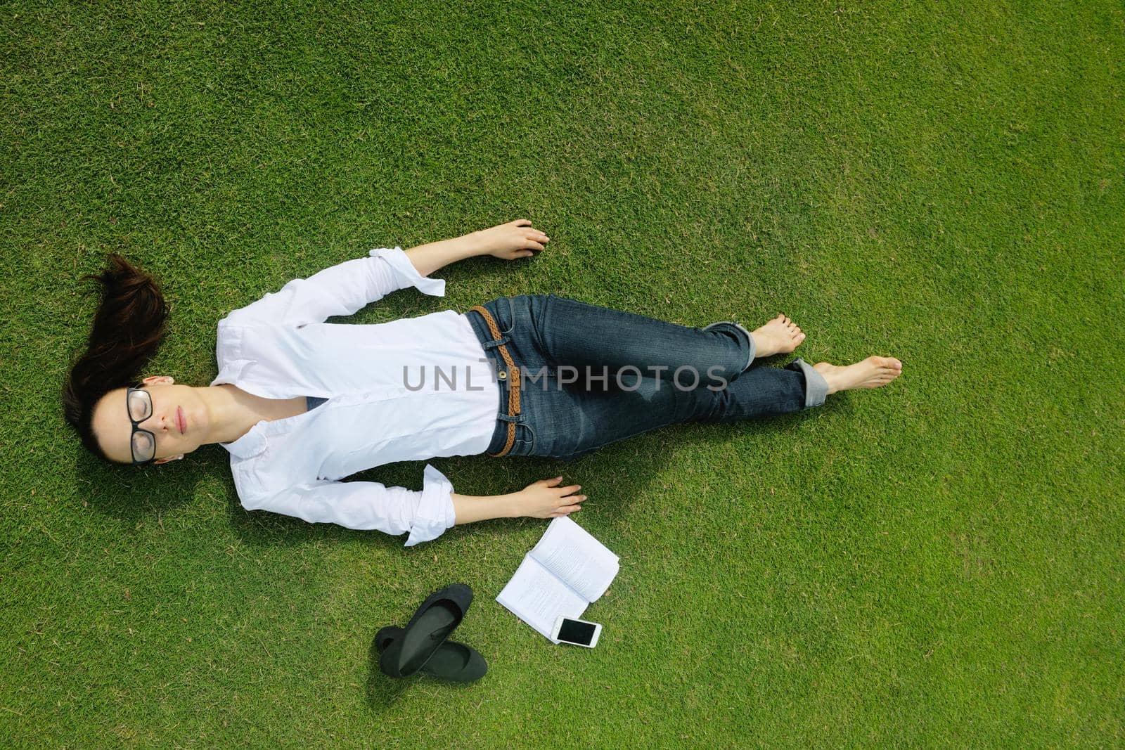 Young woman reading a book in the park by dotshock