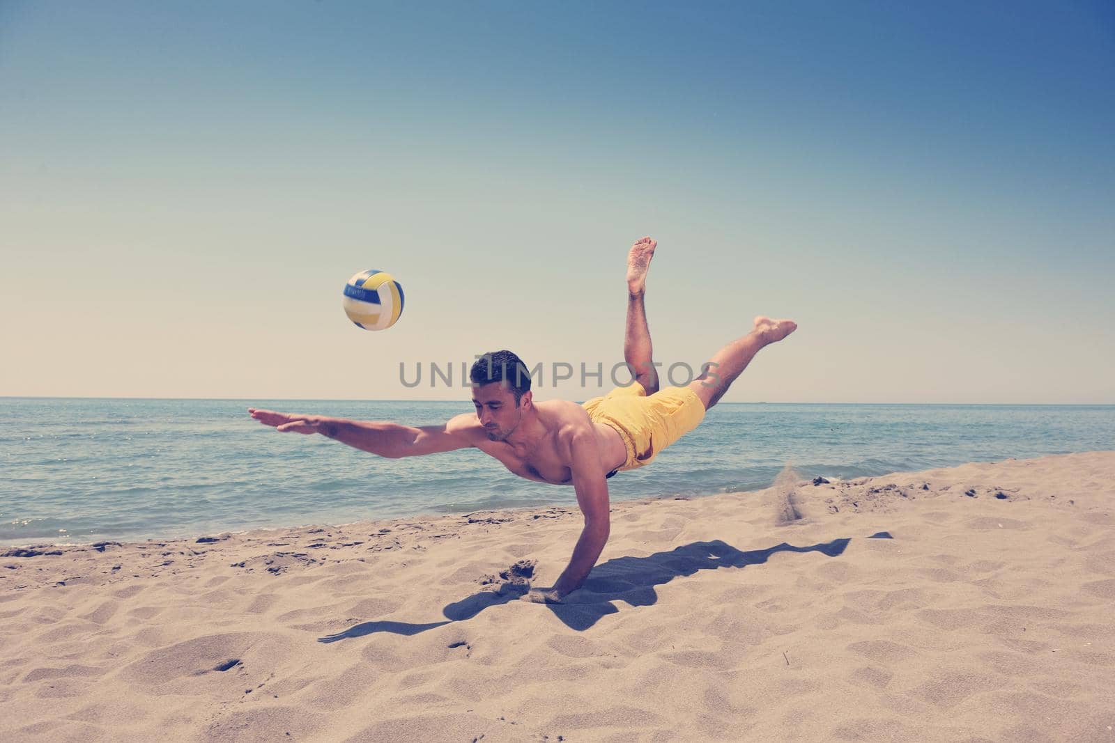 male beach volleyball game player jump on hot sand
