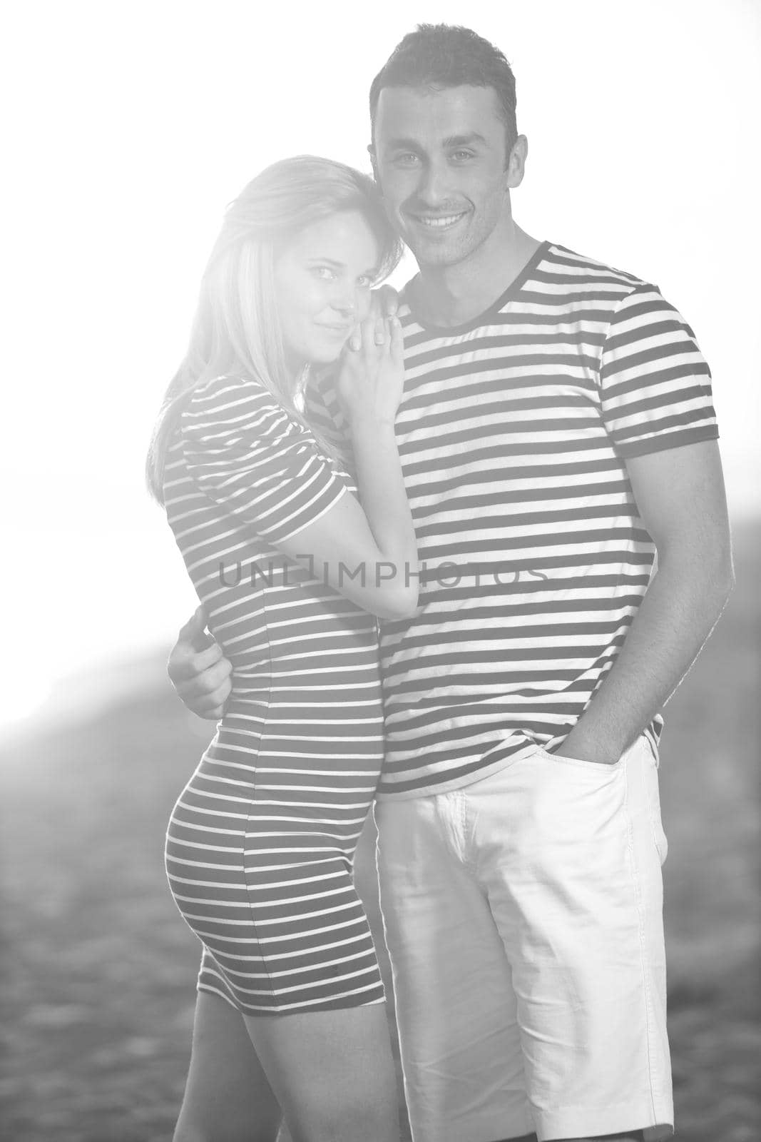 happy young couple have romantic time on beach at sunset