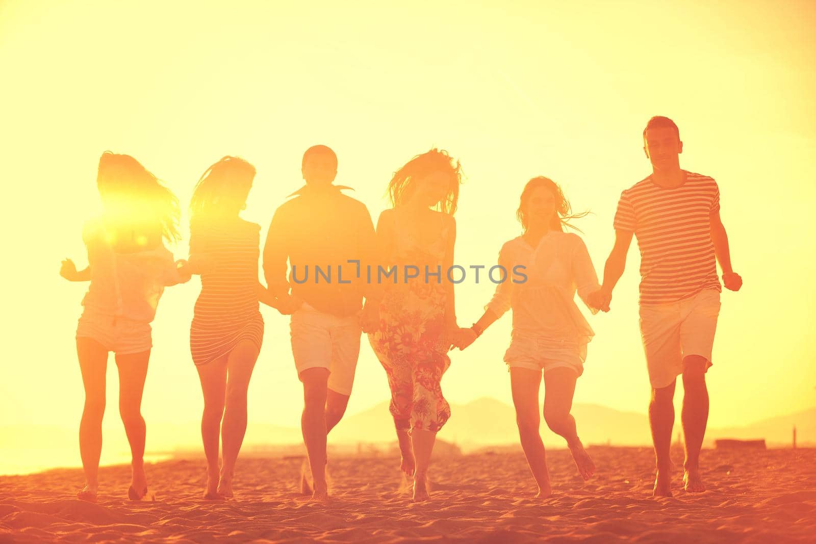 happy young  people group have fun on beach by dotshock