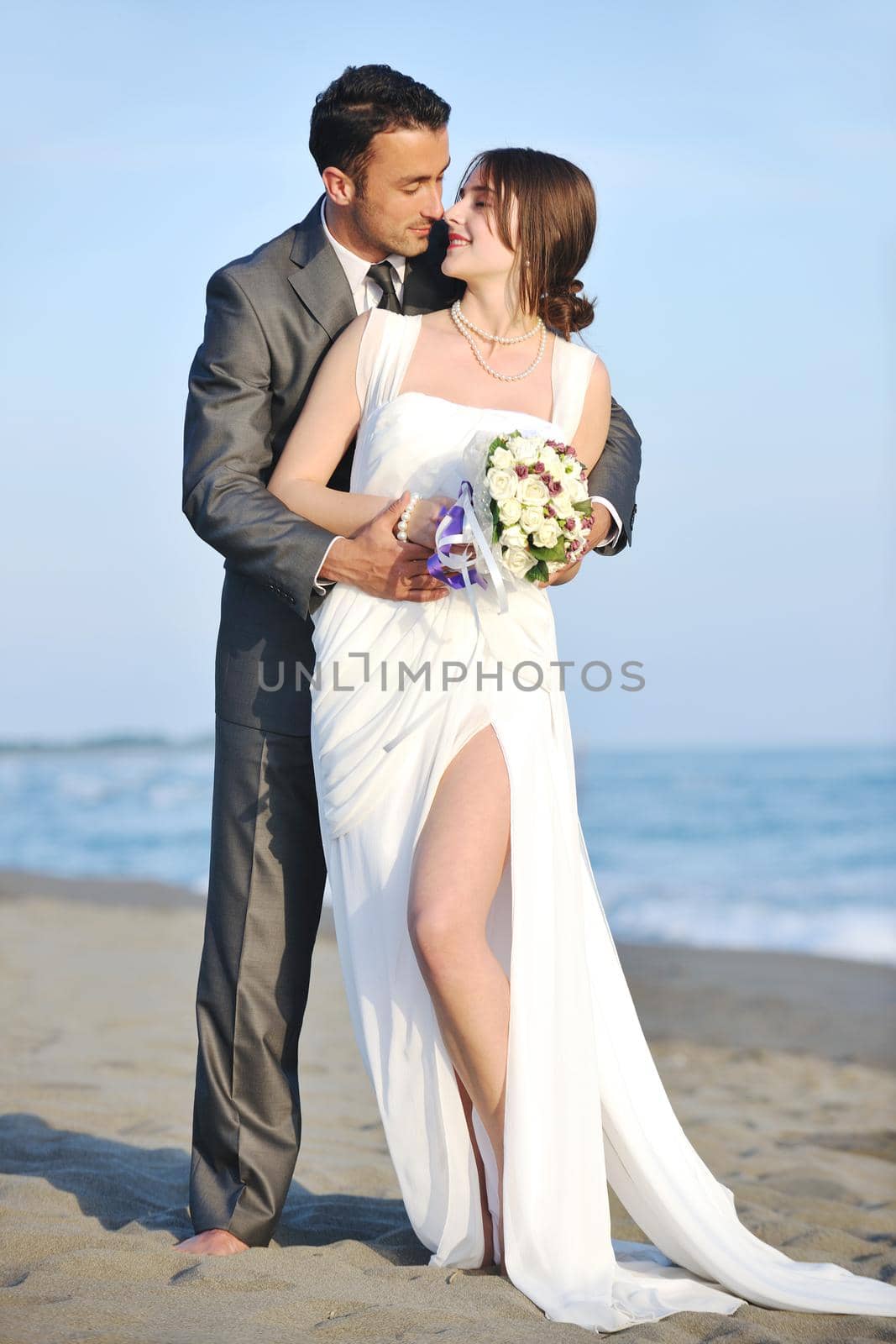 happy just married young couple celebrating and have fun at beautiful beach sunset