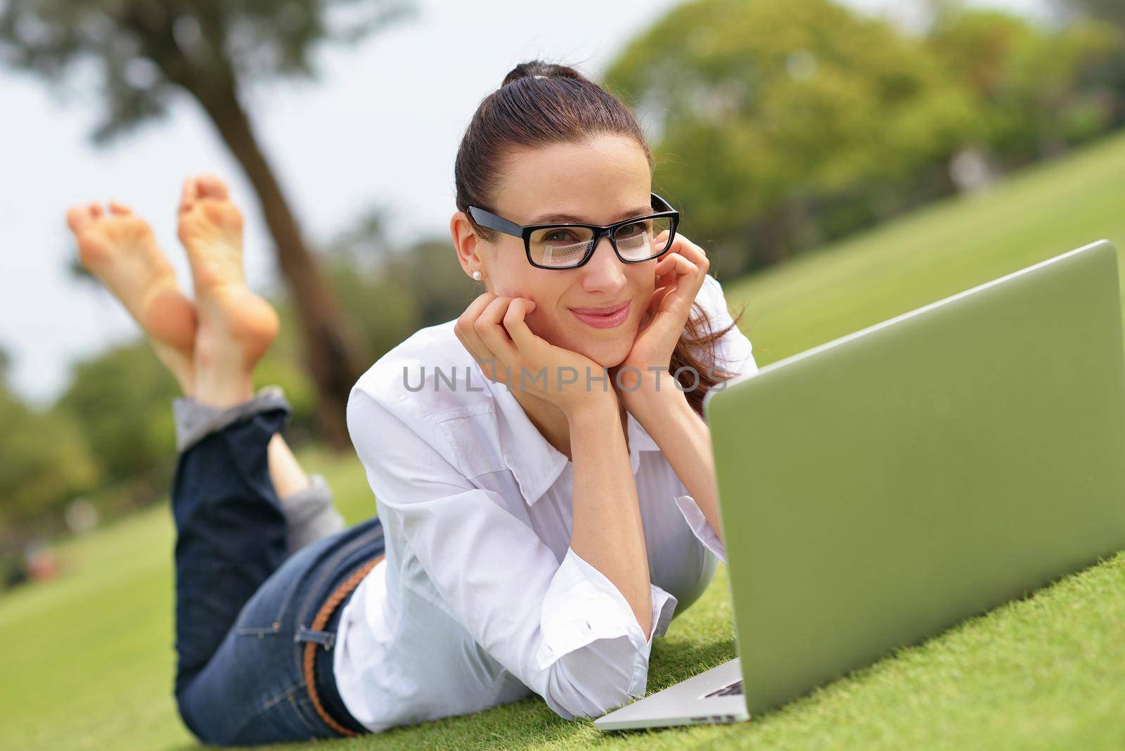 happy young student woman with laptop in city park study