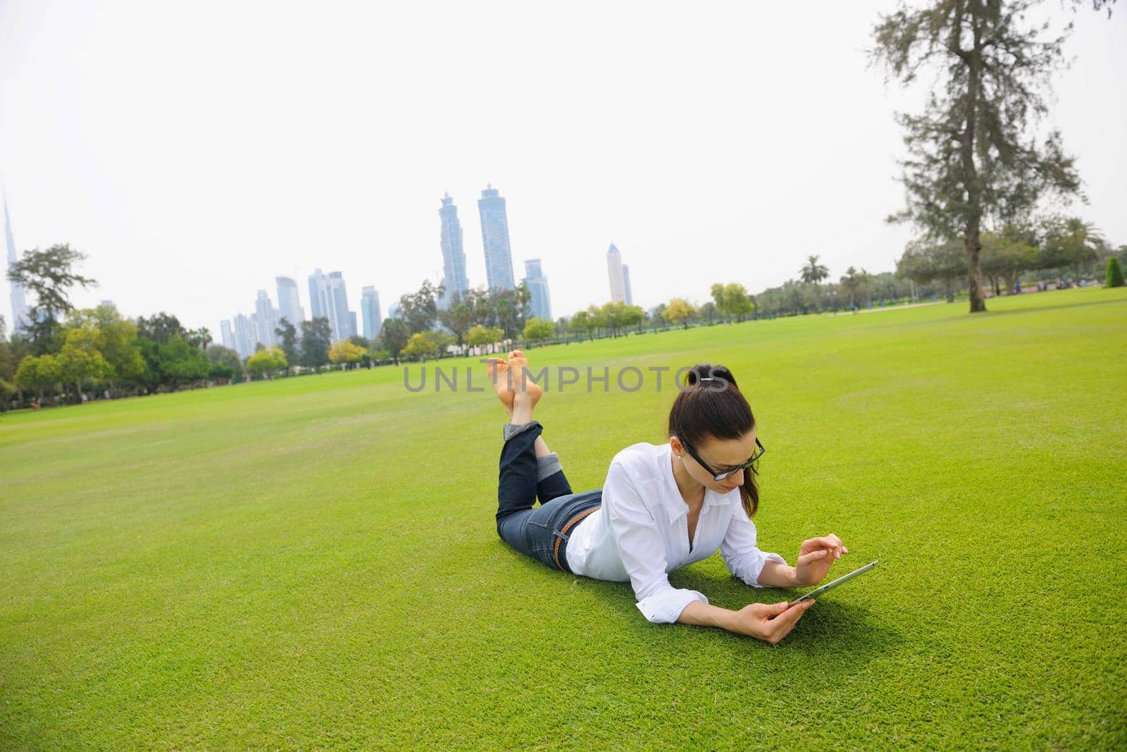 Beautiful young woman with  tablet in park by dotshock