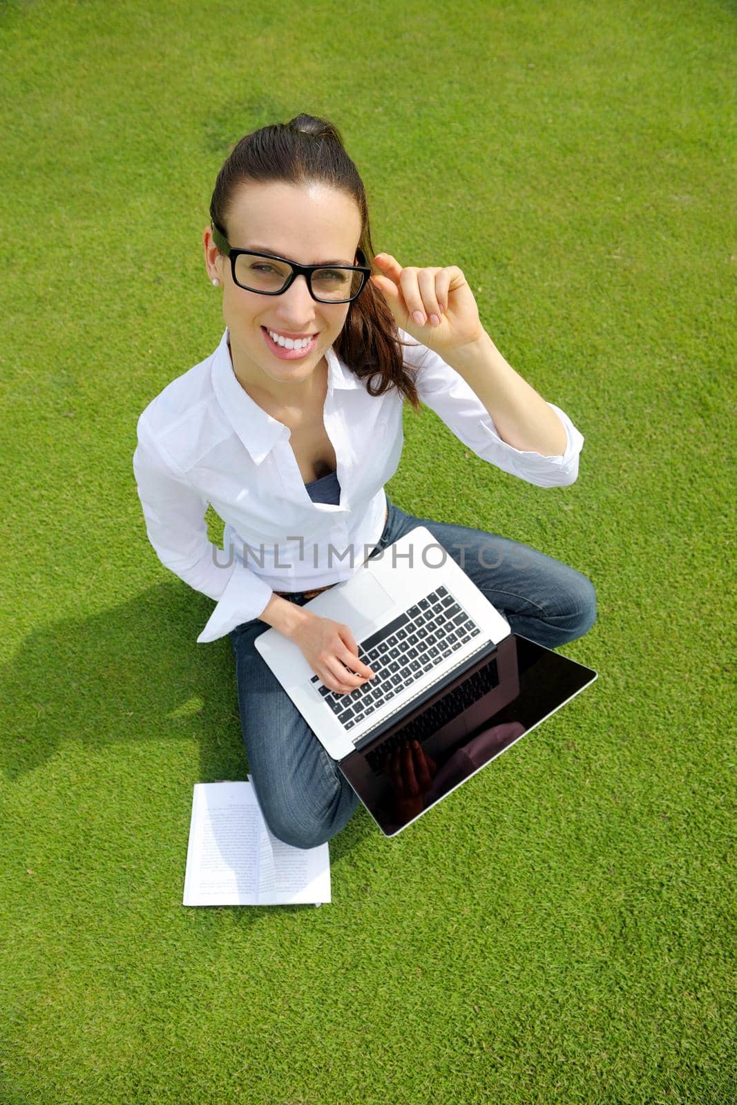 happy young student woman with laptop in city park study