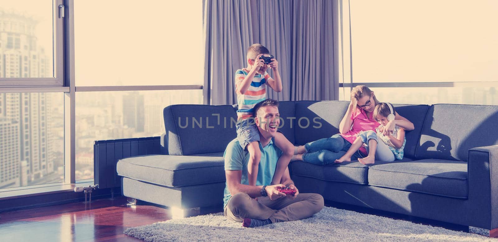 Happy family. Father, mother and children playing a video game Father and son playing video games together on the floor