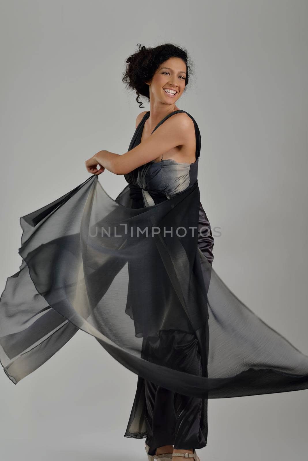 elegant woman in fashionable dress posing in the studio by dotshock