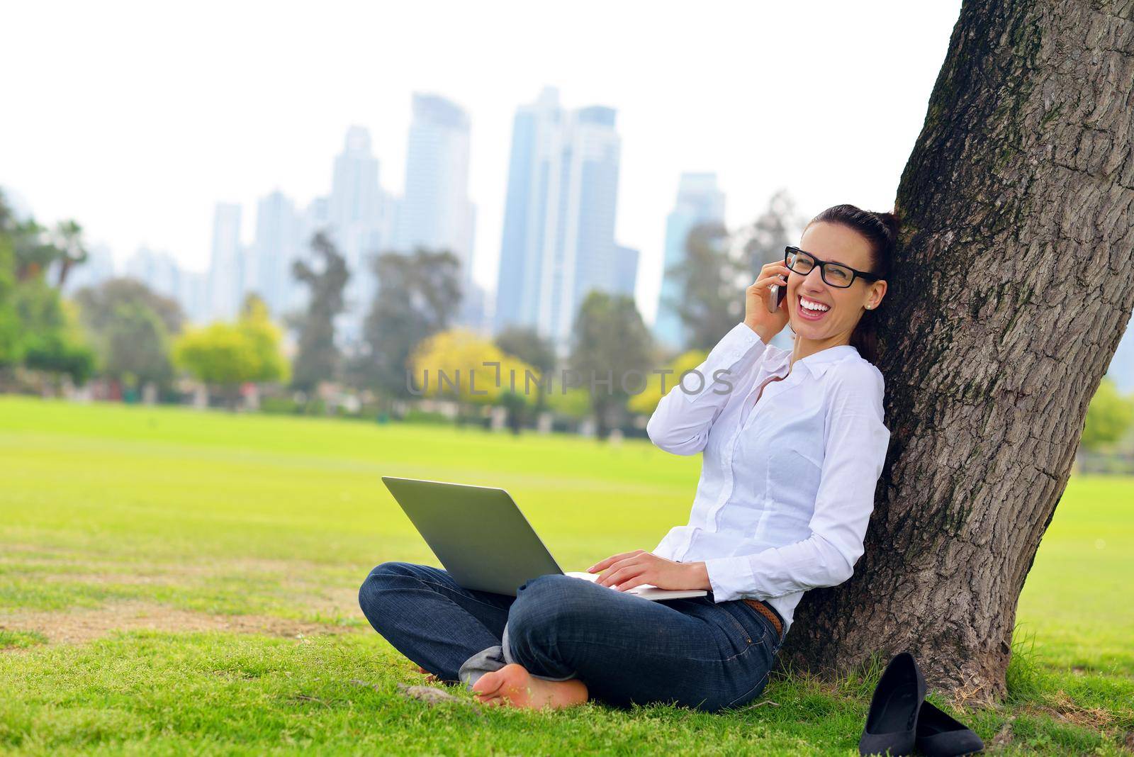 happy young student woman with laptop in city park study