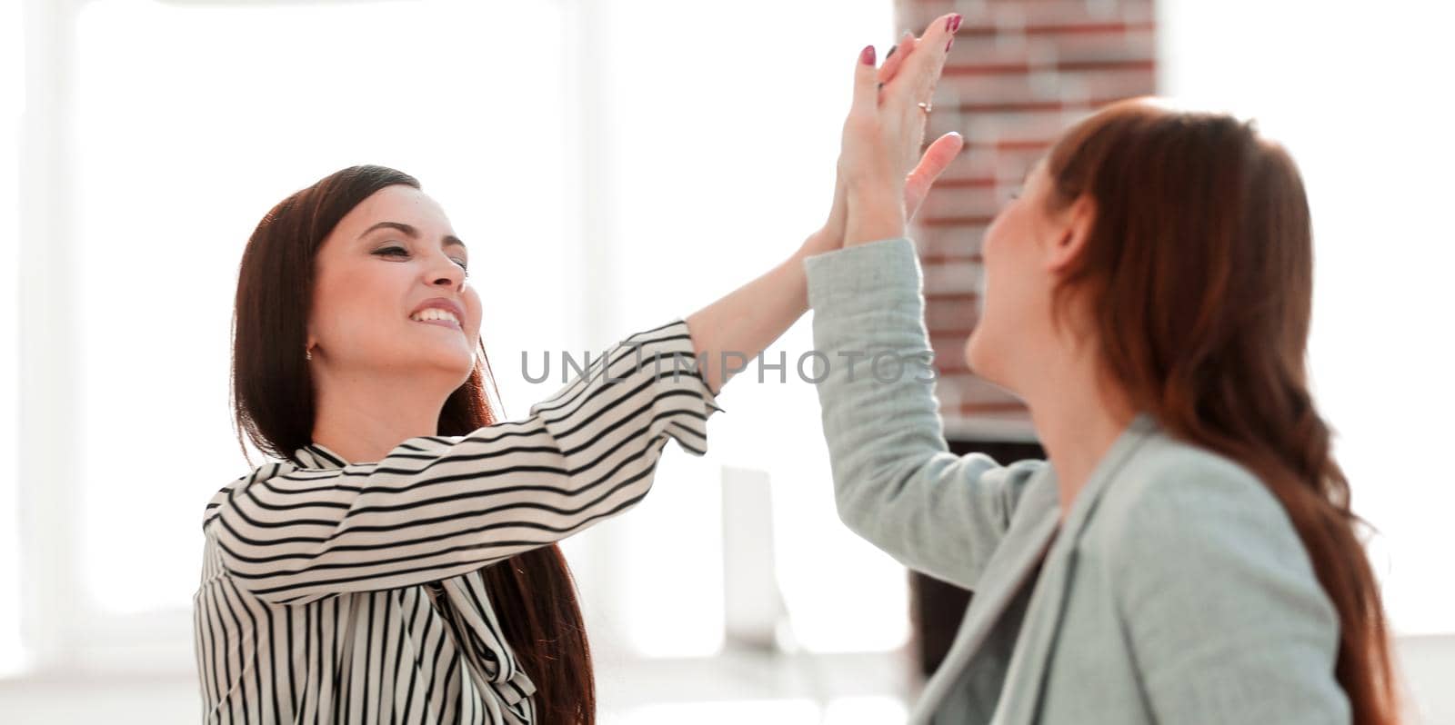 two young co-workers giving each other a high five. success concept