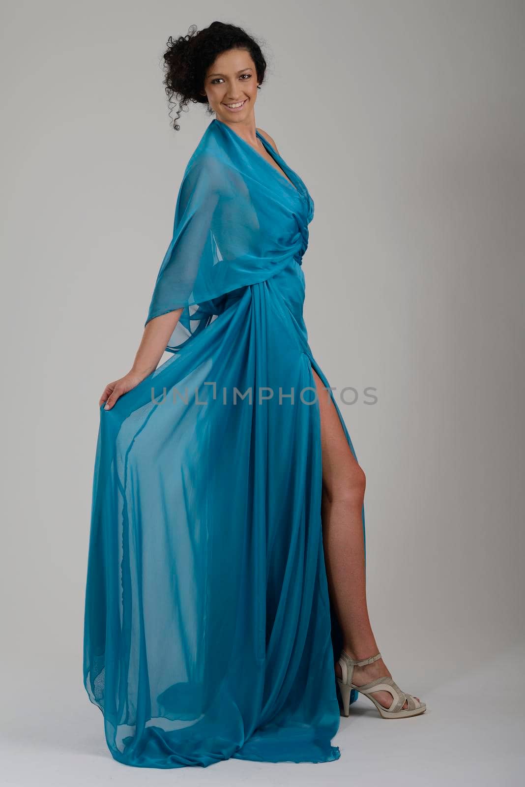 elegant woman in fashionable dress posing in the studio by dotshock