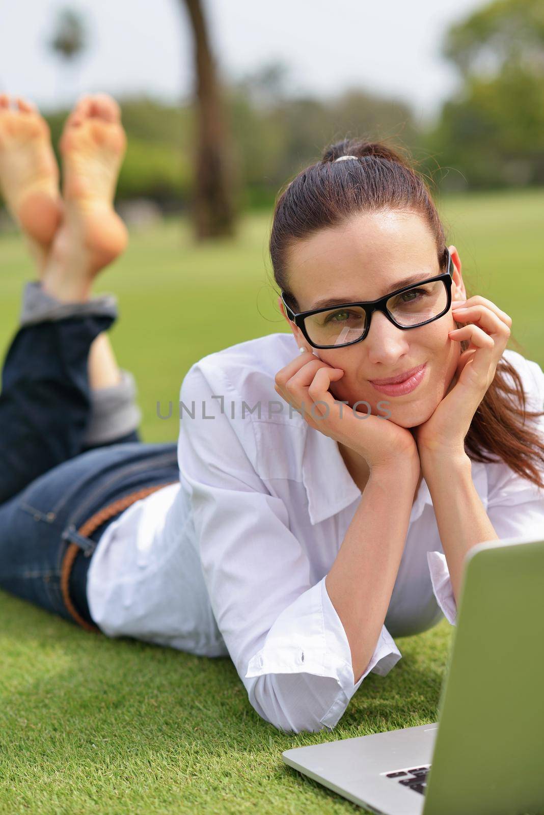 happy young student woman with laptop in city park study