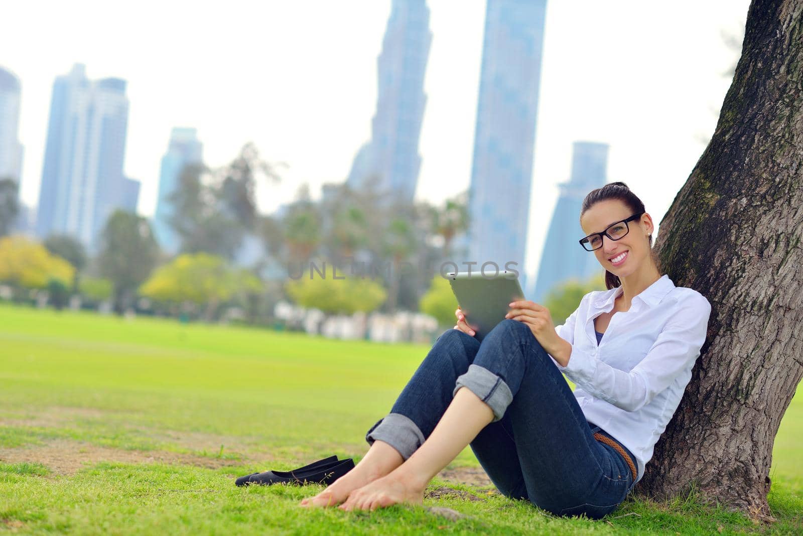 Beautiful young woman with  tablet in park by dotshock