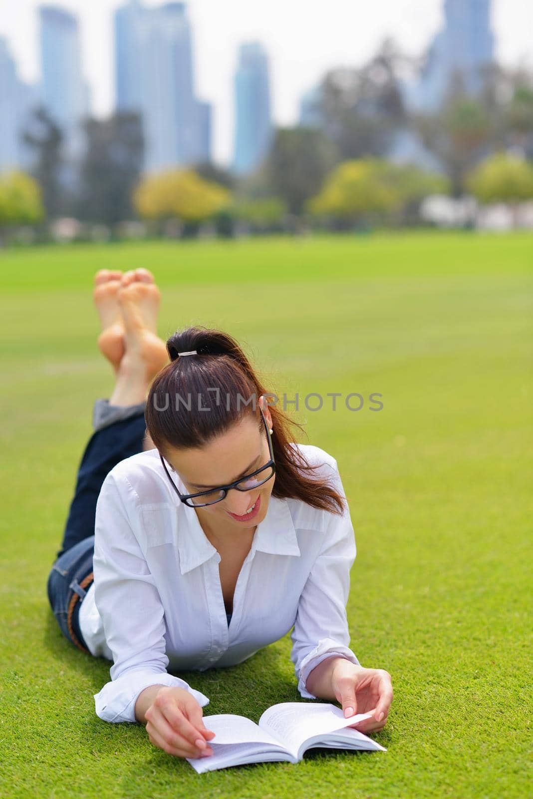 Young student woman reading a book and study in the park