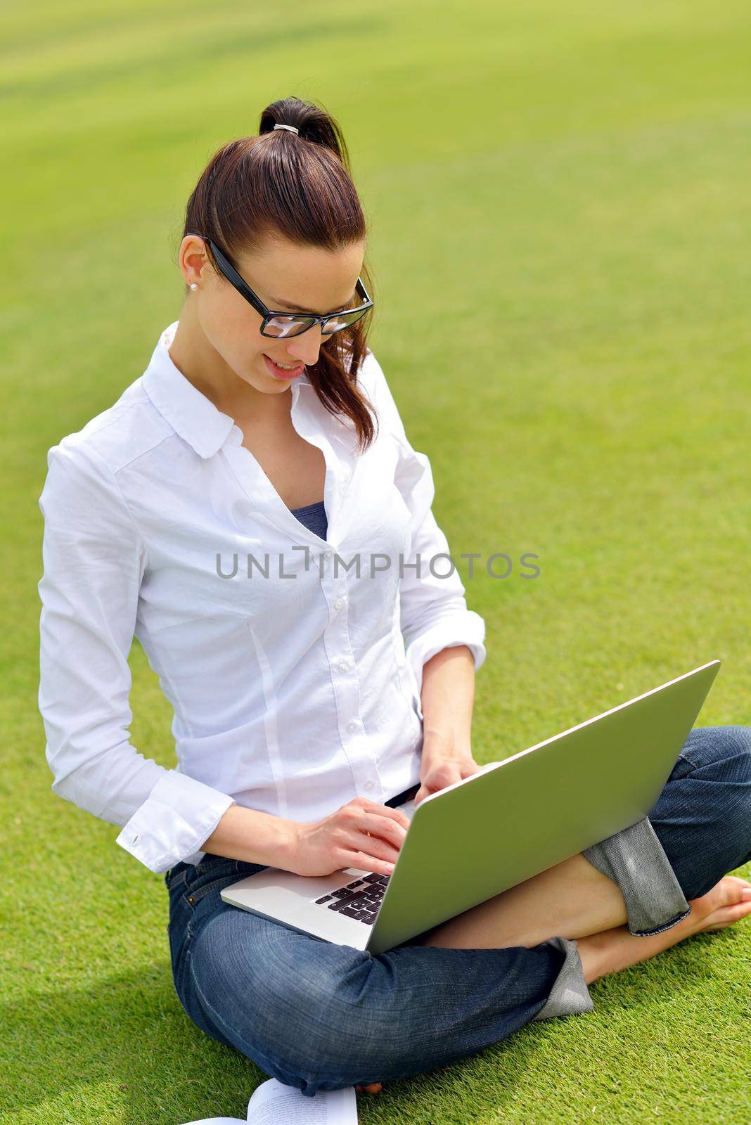 happy young student woman with laptop in city park study