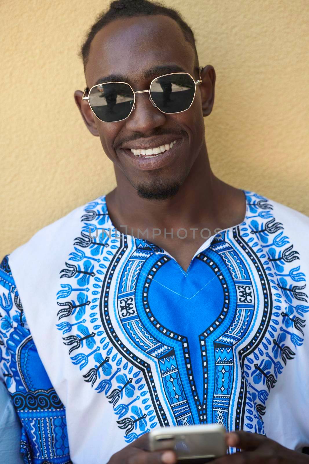 Native Sudan black african man using smart phone and wearing traditional clothes