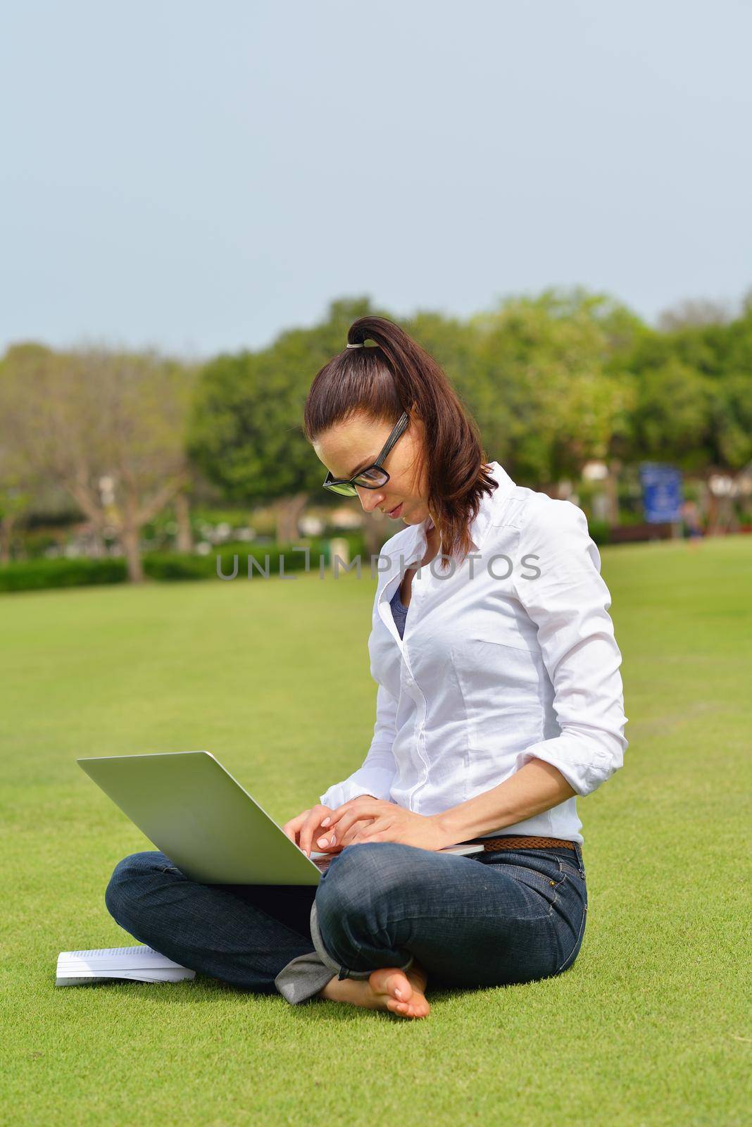 happy young student woman with laptop in city park study