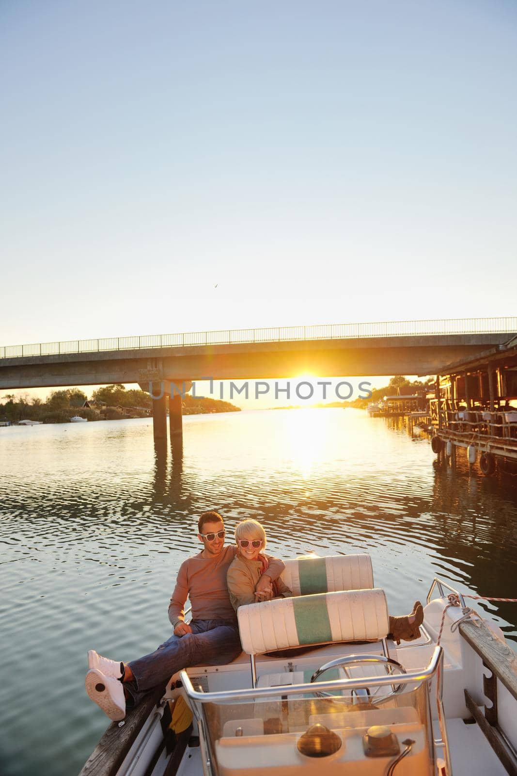 happy young couple in love  have romantic time at summer sunset   at ship boat while  representing urban and countryside fashin lifestyle