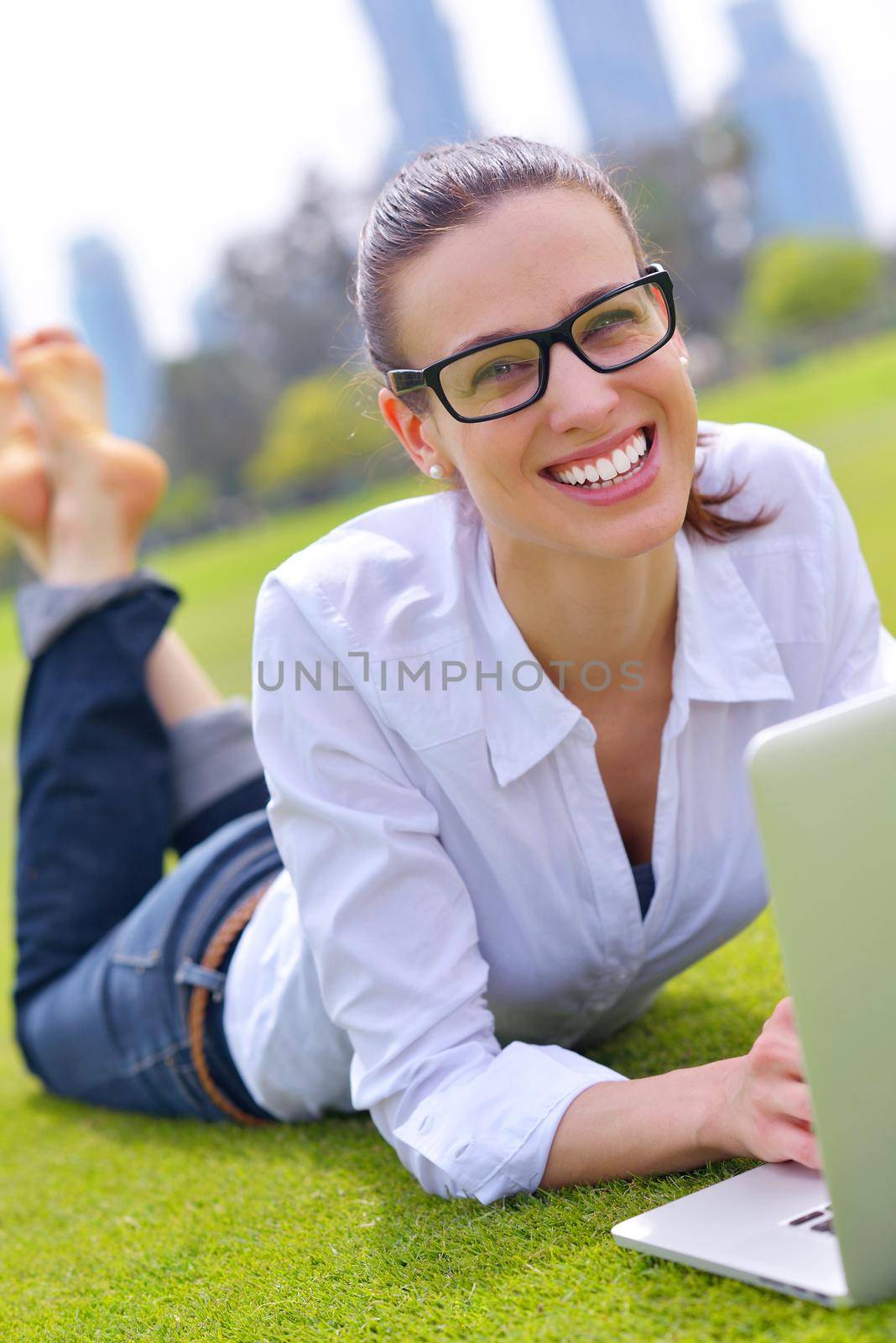 happy young student woman with laptop in city park study