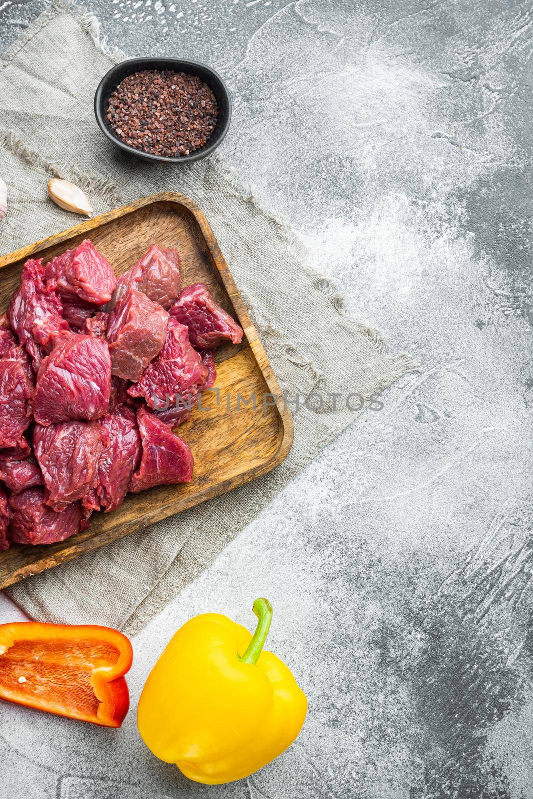 Beef stew prepared for goulash cooking set, on gray stone background, top view flat lay, with copy space for text