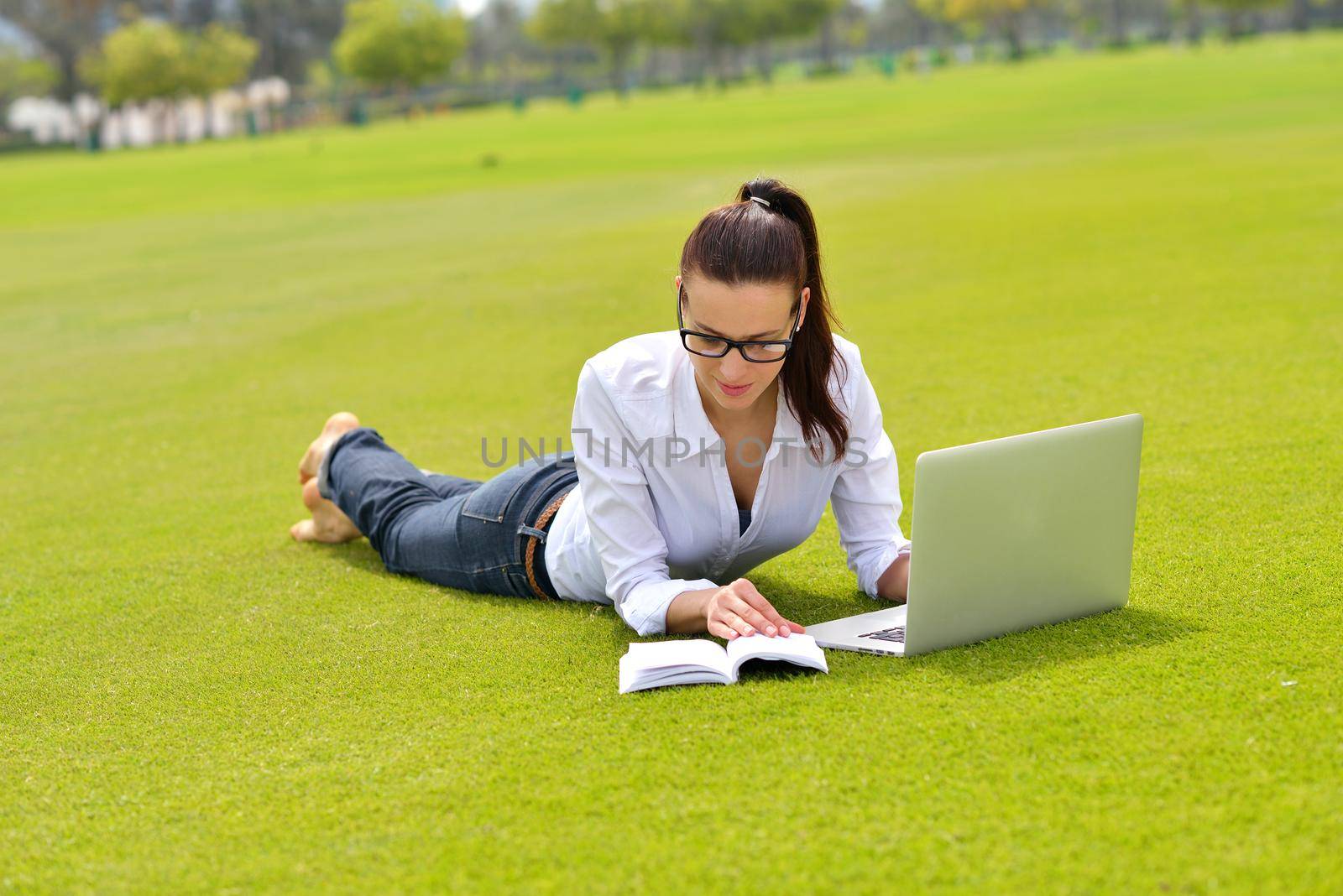 happy young student woman with laptop in city park study