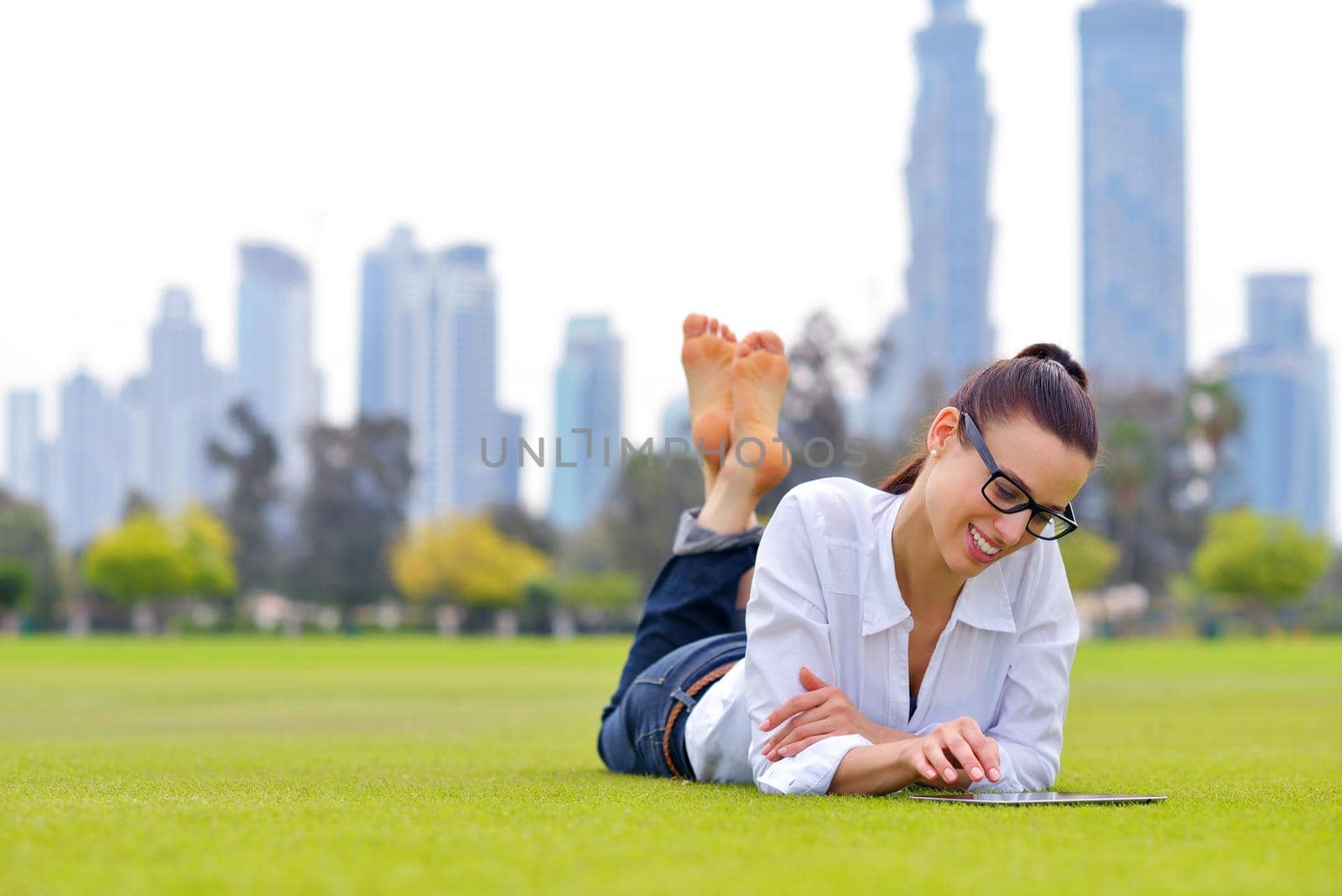 Beautiful young woman with  tablet in park by dotshock