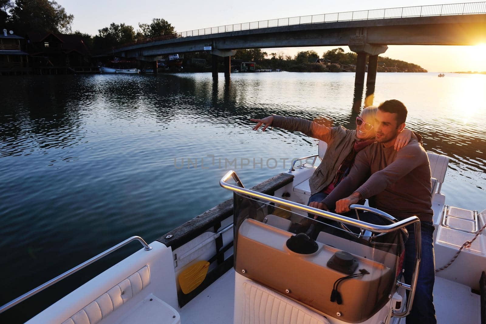 happy young couple in love  have romantic time at summer sunset   at ship boat while  representing urban and countryside fashin lifestyle