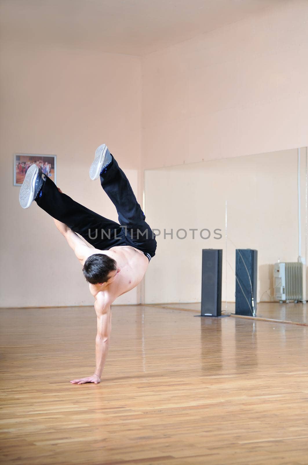 young man performing break dance in dance studio