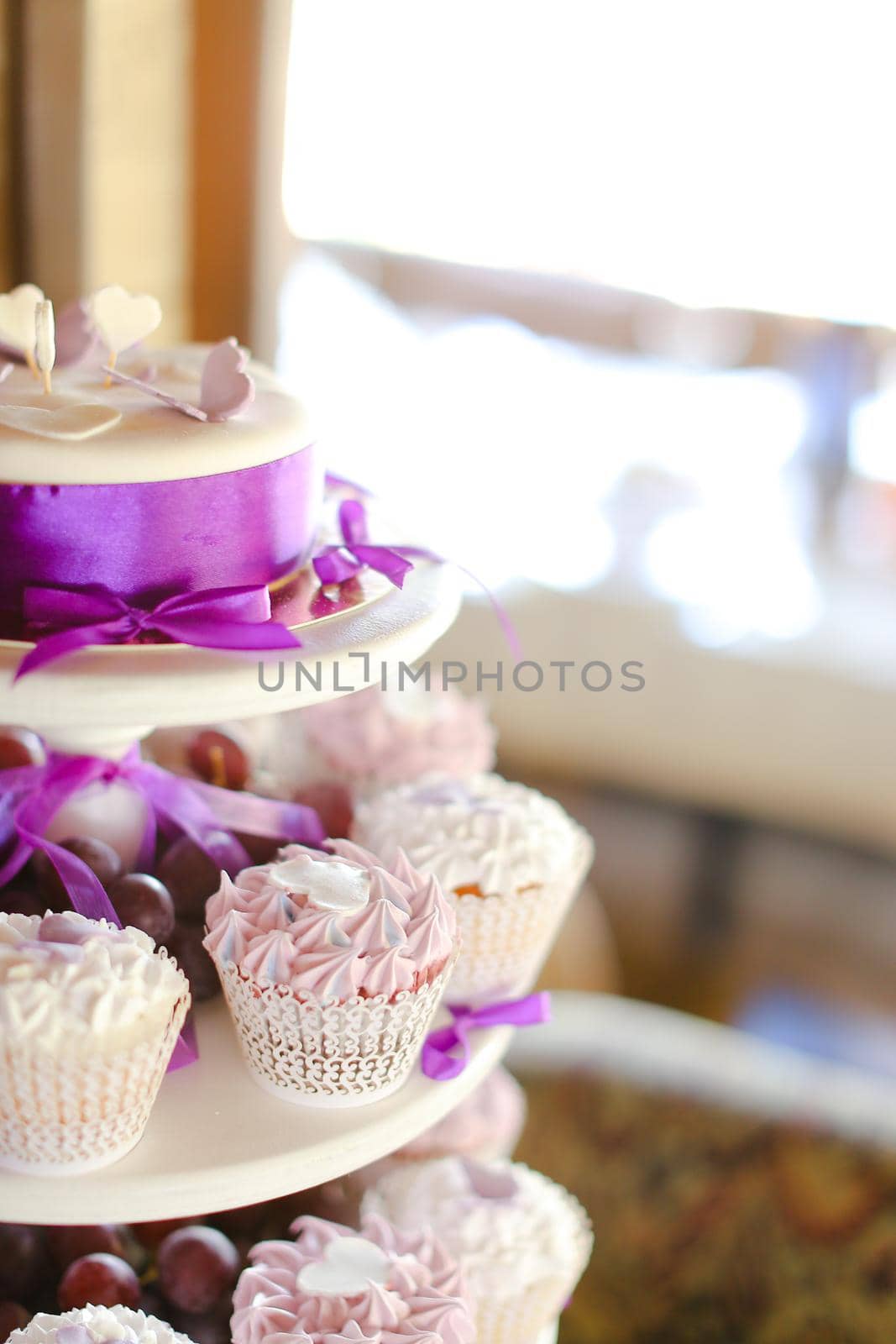 Violet decorations and sweet cakes for party. Concept of birthday sweets and tasty food.