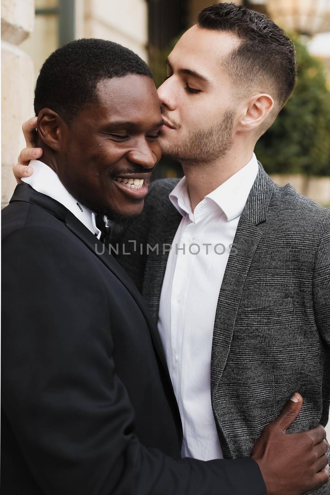 Afro american gay hugging european man outdoors. Concept of lgbt and same sex couple.