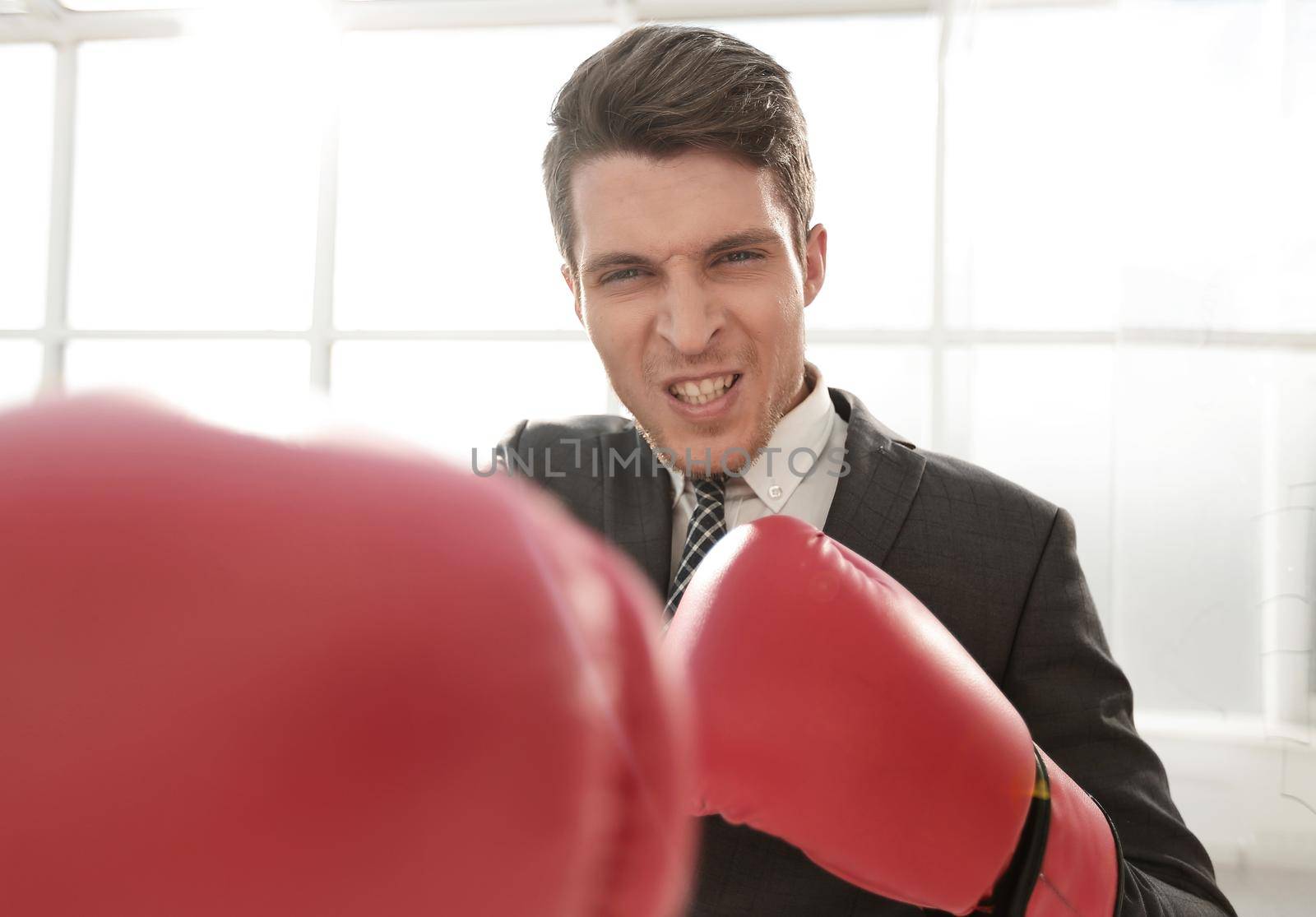 purposeful young businessman in Boxing gloves. concept of competitiveness