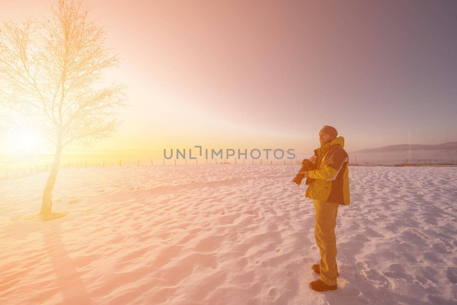 portrait of male photographer on sunset at winter nature by dotshock