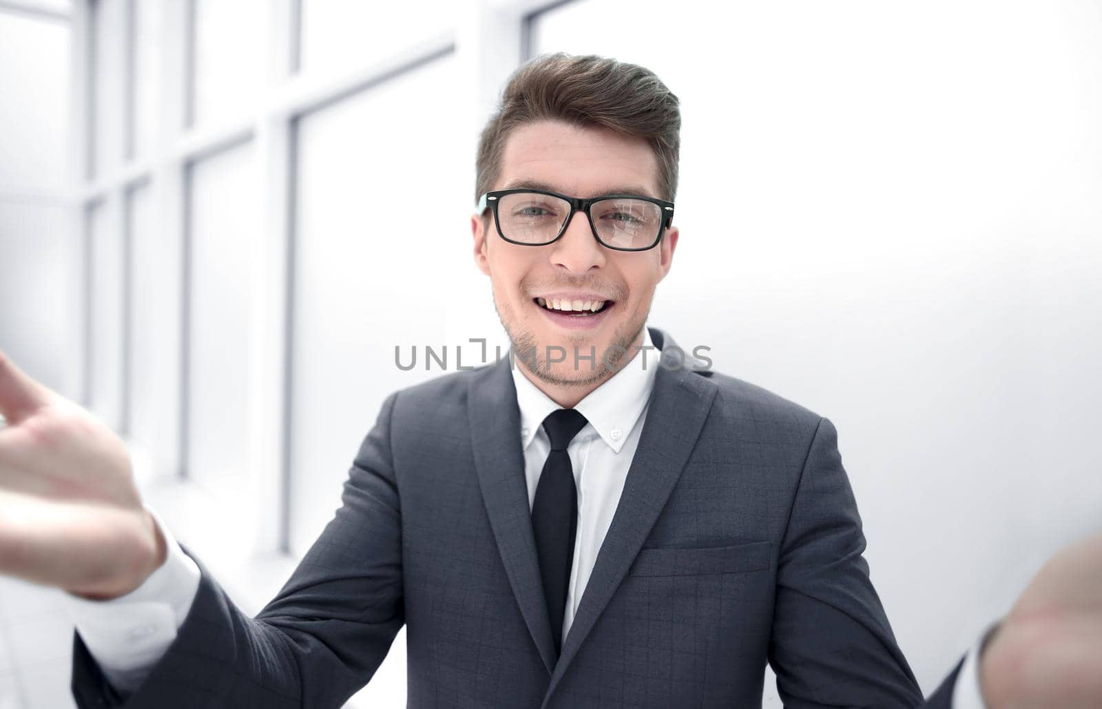 close up.surprised young businessman standing near the window.