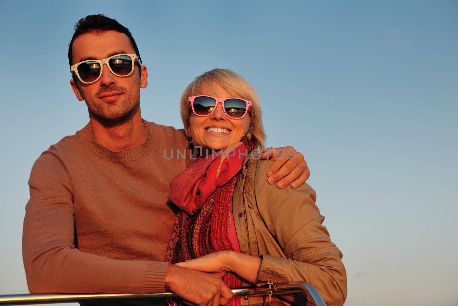 happy young couple in love  have romantic time at summer sunset   at ship boat while  representing urban and countryside fashin lifestyle