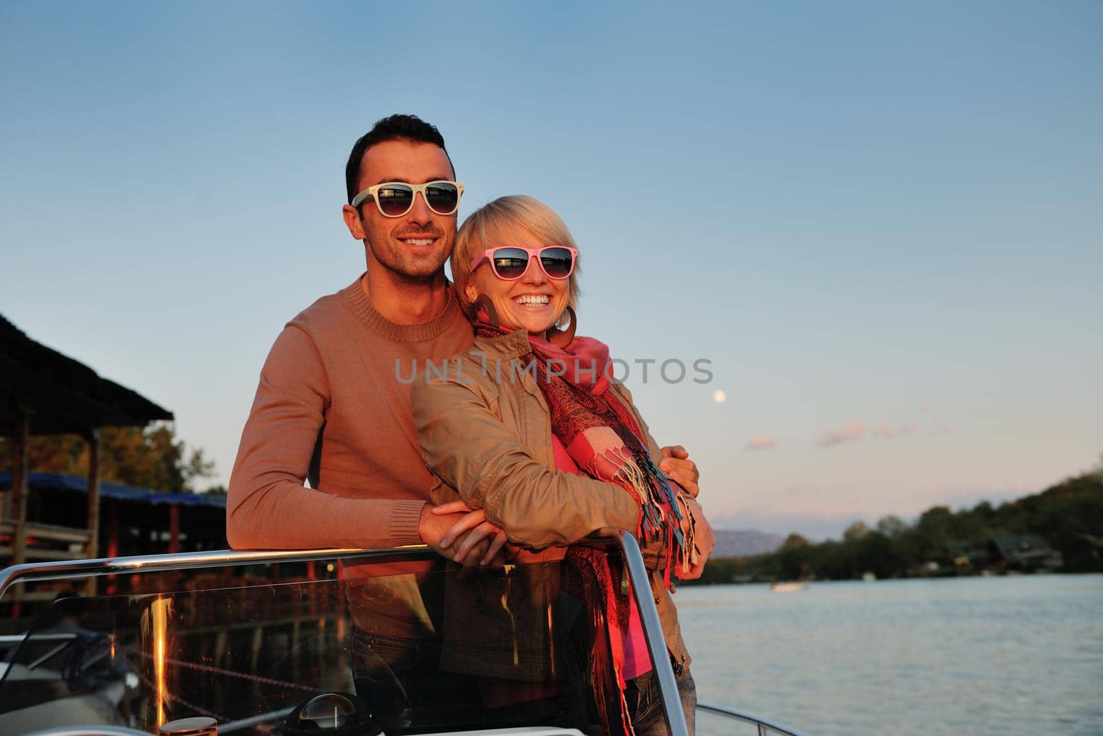 happy young couple in love  have romantic time at summer sunset   at ship boat while  representing urban and countryside fashin lifestyle