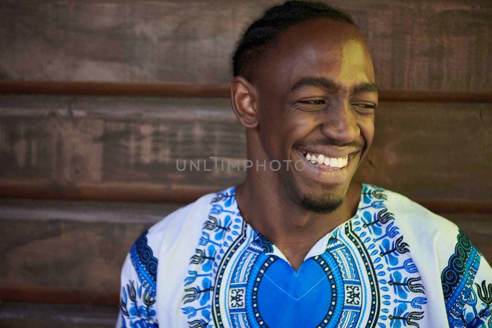 portrait of a smiling young african man wearing traditioinal clothes by dotshock