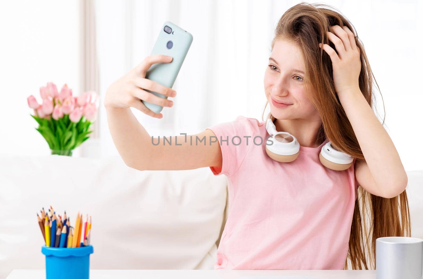 Beatiful teen making selfie of herself in cool headphones on breaks