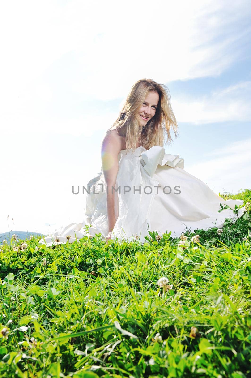 happy young beautiful bride after wedding ceremony event have fun outdoor on meadow at sunset