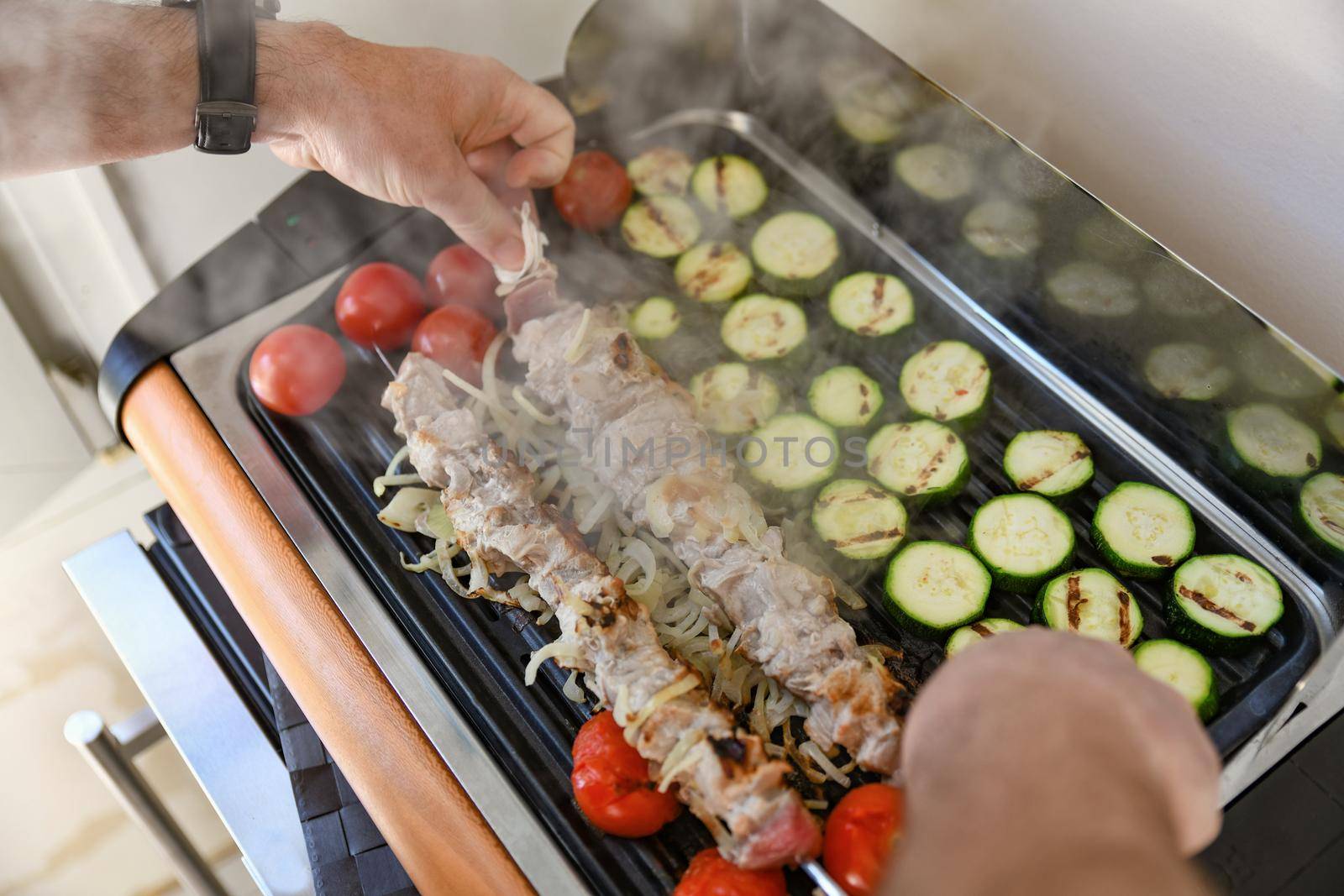 Meat on skewers with vegetables on the barbecue grill