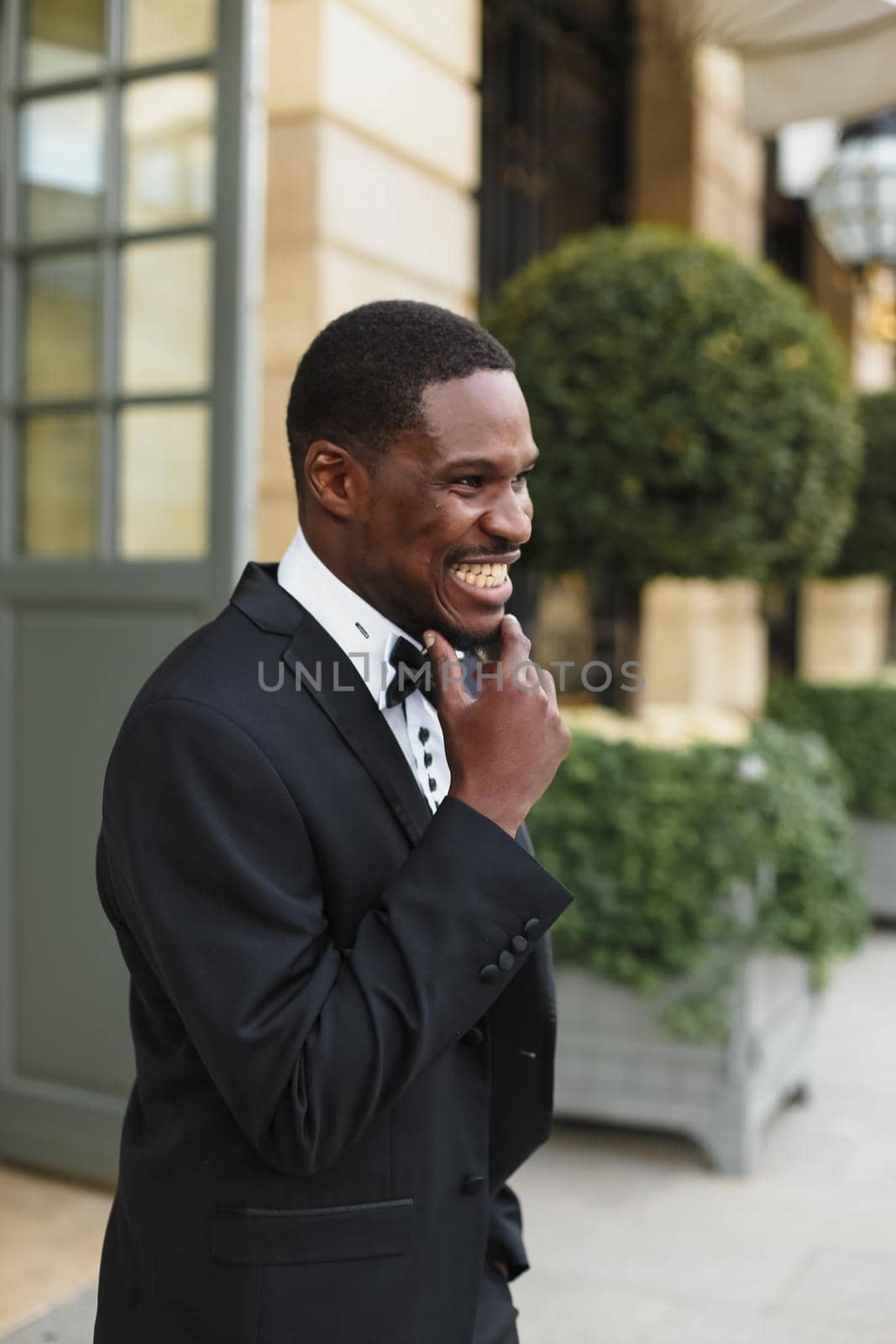 Afro american happy good looking man wearing suit and smiling outdoors. Concept of black businessman.