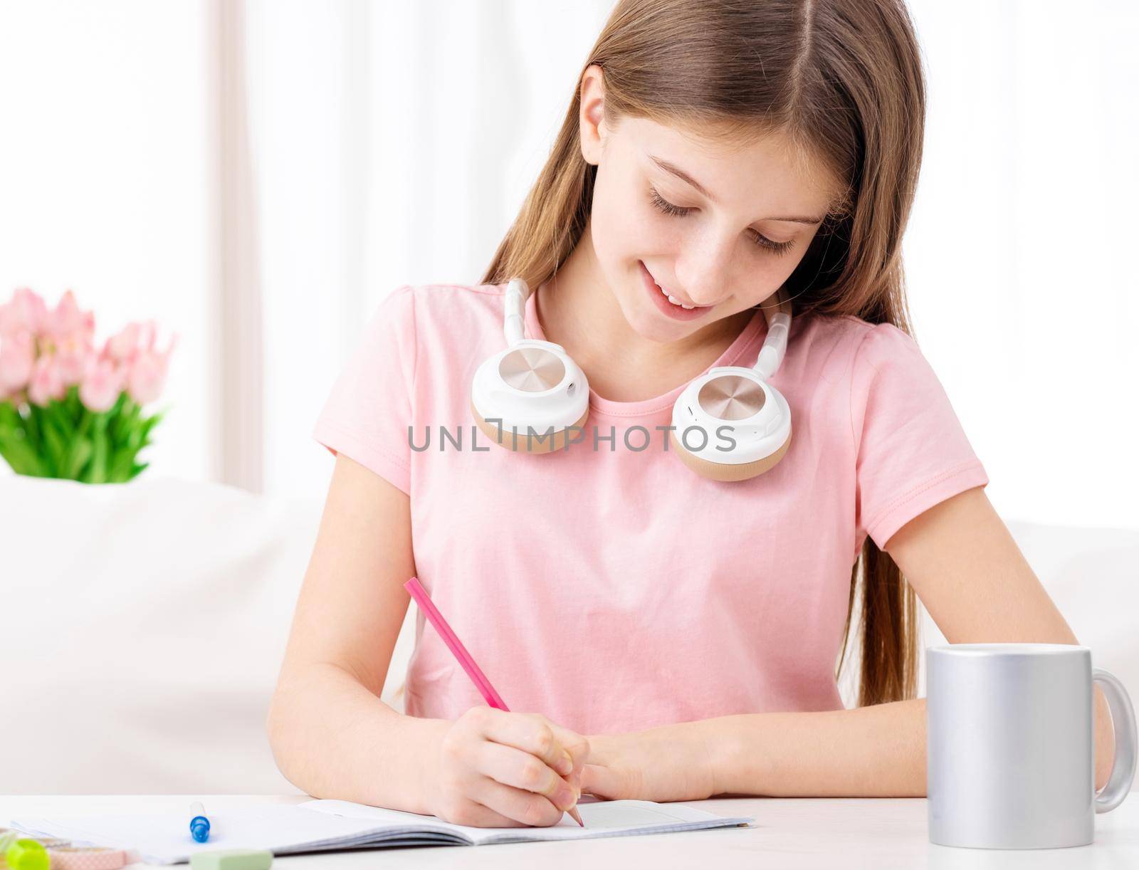 Pretty school girl making homework at home