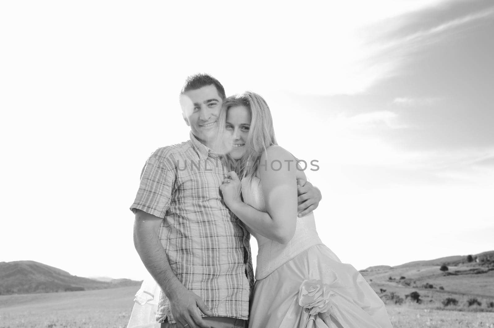 happy bride and groom walking and run on beautiful meadow outdoor at sunset