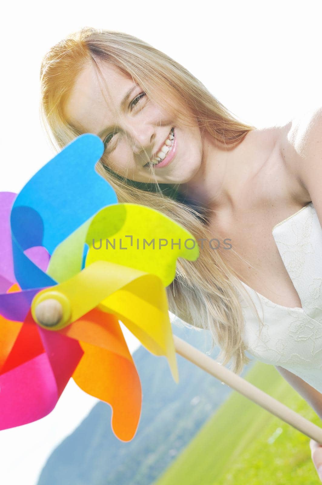 happy young beautiful bride after wedding ceremony event have fun outdoor on meadow at sunset with windmill toy and representing smart energy 