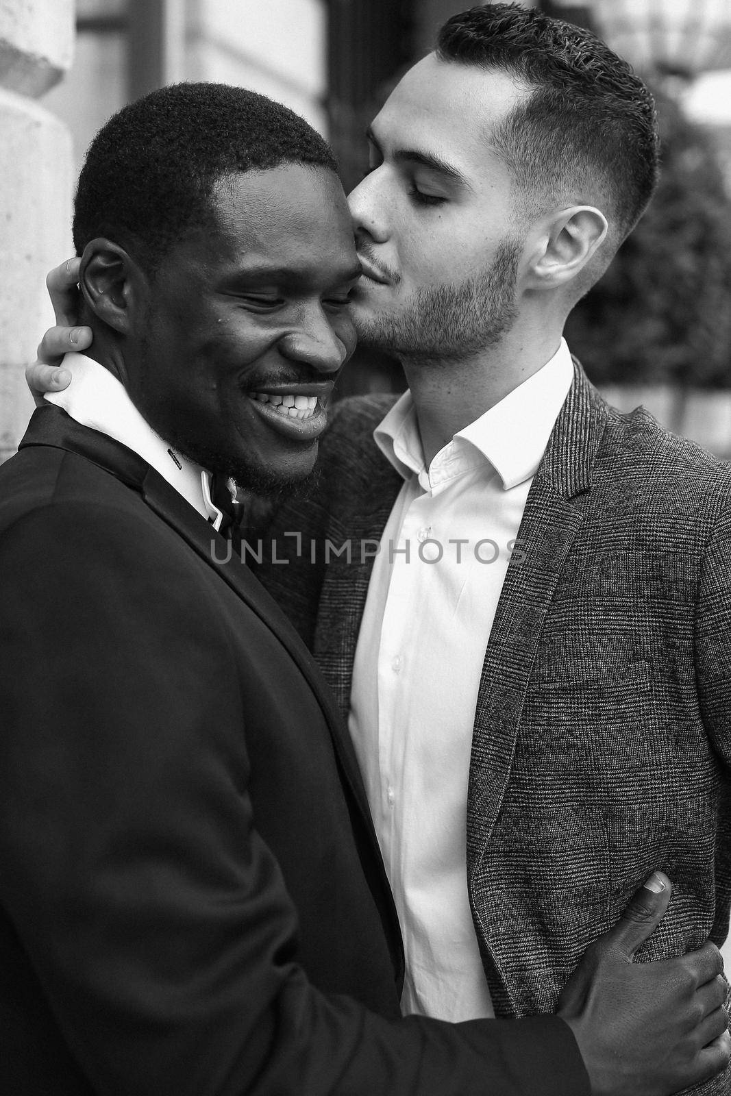 Black and white bw portrait in Paris. afro american gay hugging european man outdoors. Concept of lgbt and same sex couple.