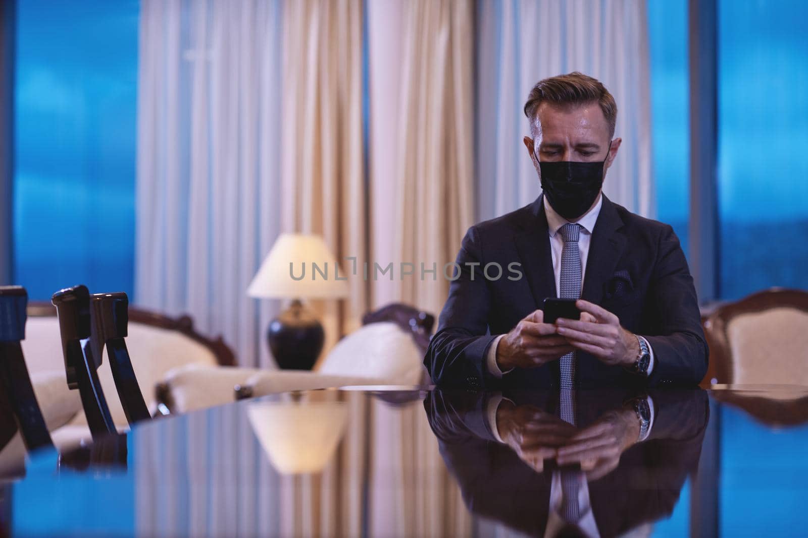 corporate business man wearing face mask and  using smart phone at luxury office