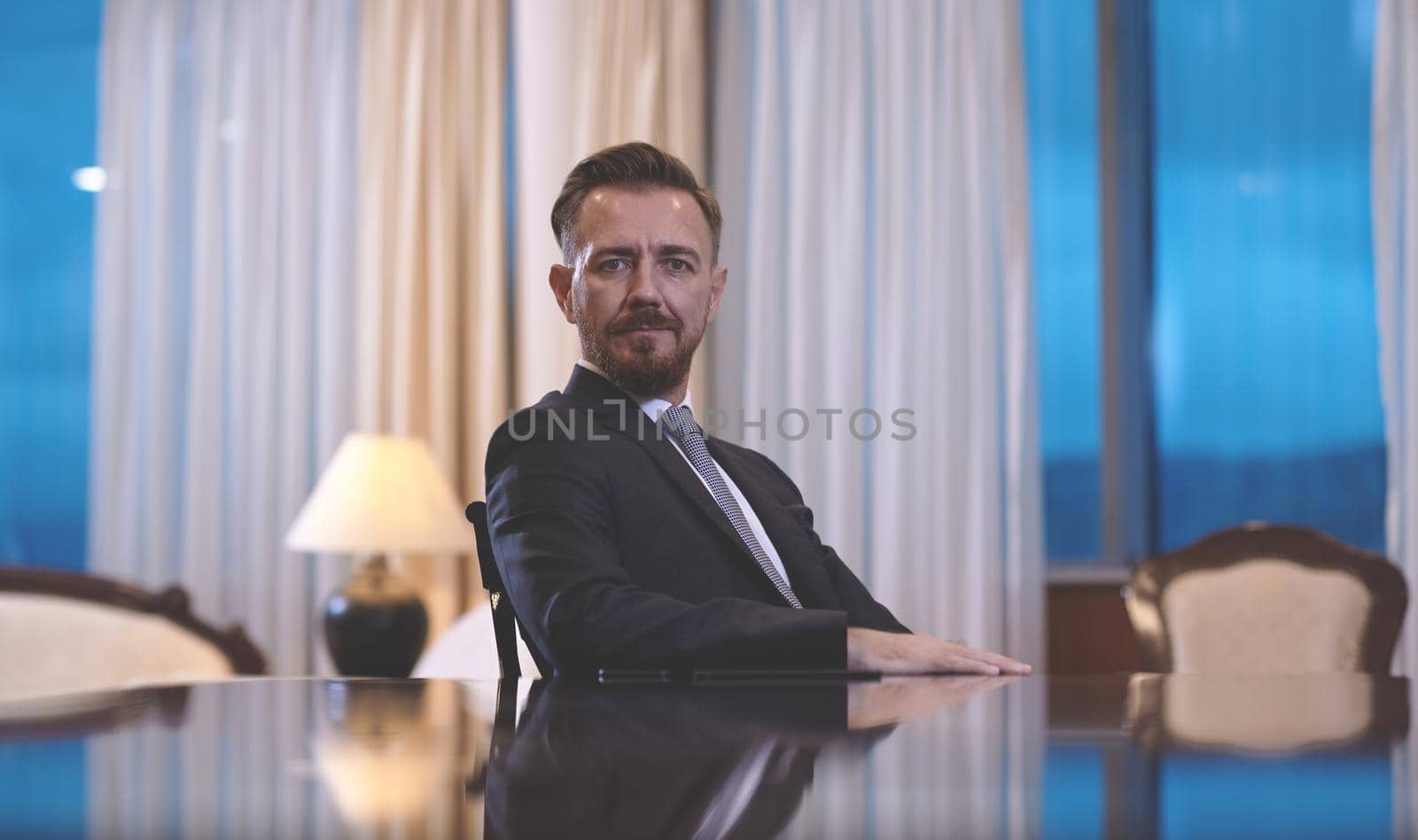 Senior executive businessman at luxury corporate workspace. Portrait of smiling ceo at modern office in stylish suit