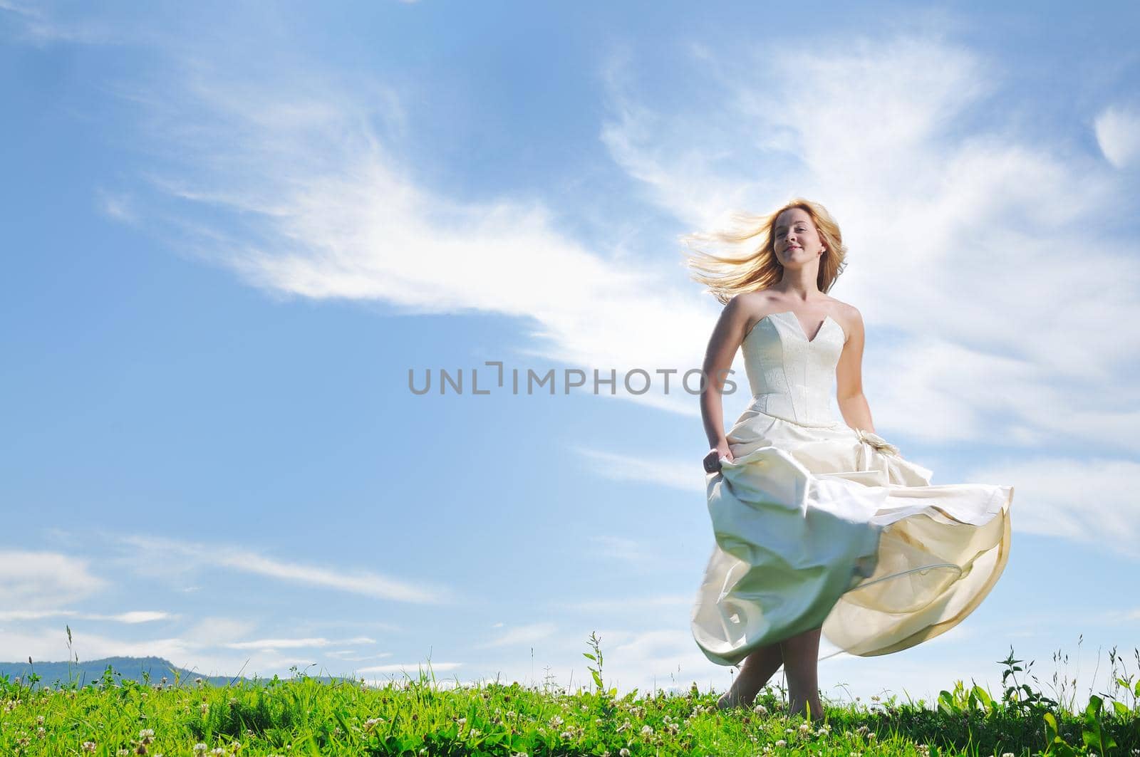 happy young beautiful bride after wedding ceremony event have fun outdoor on meadow at sunset