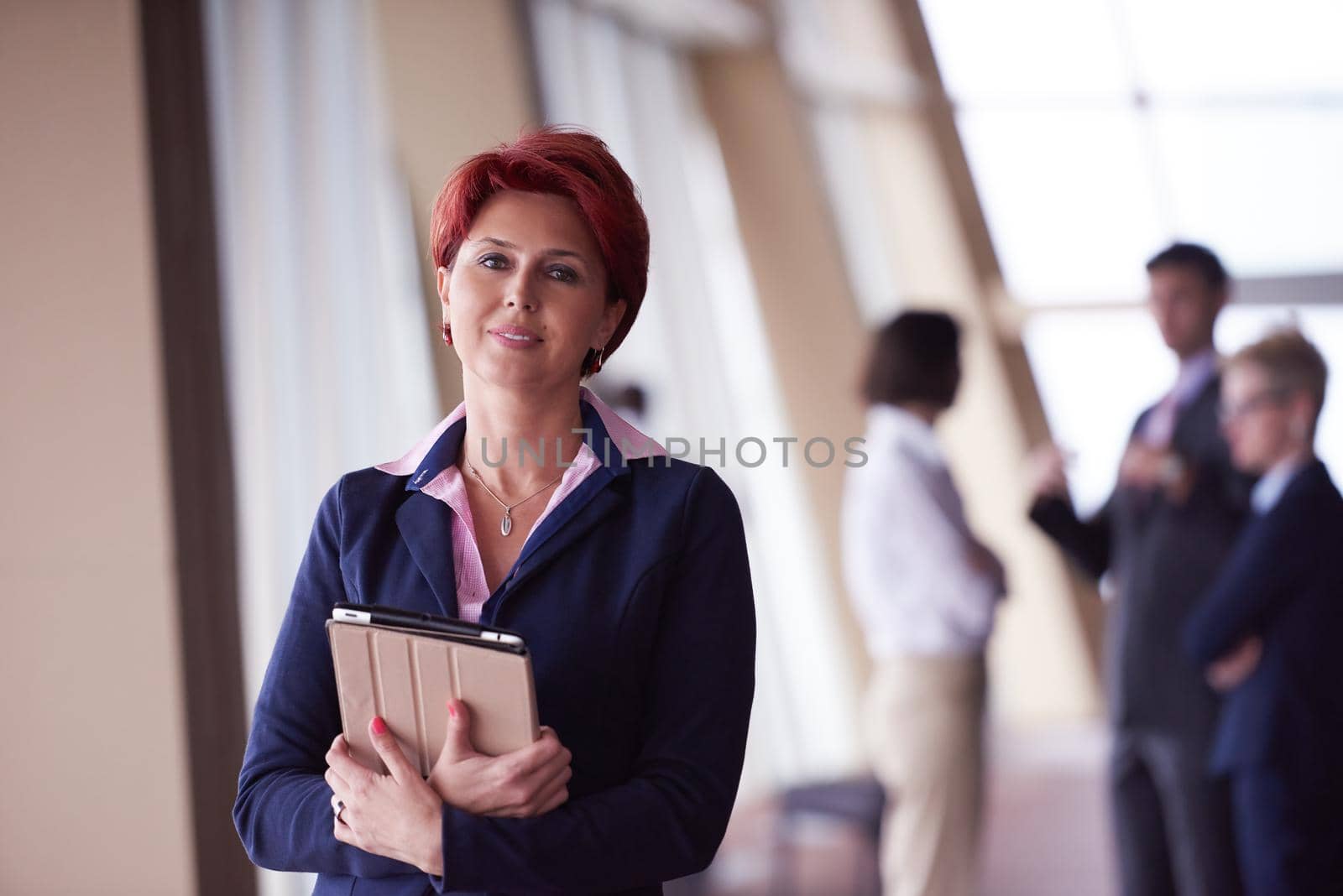 business woman  at office with tablet  in front  as team leader by dotshock