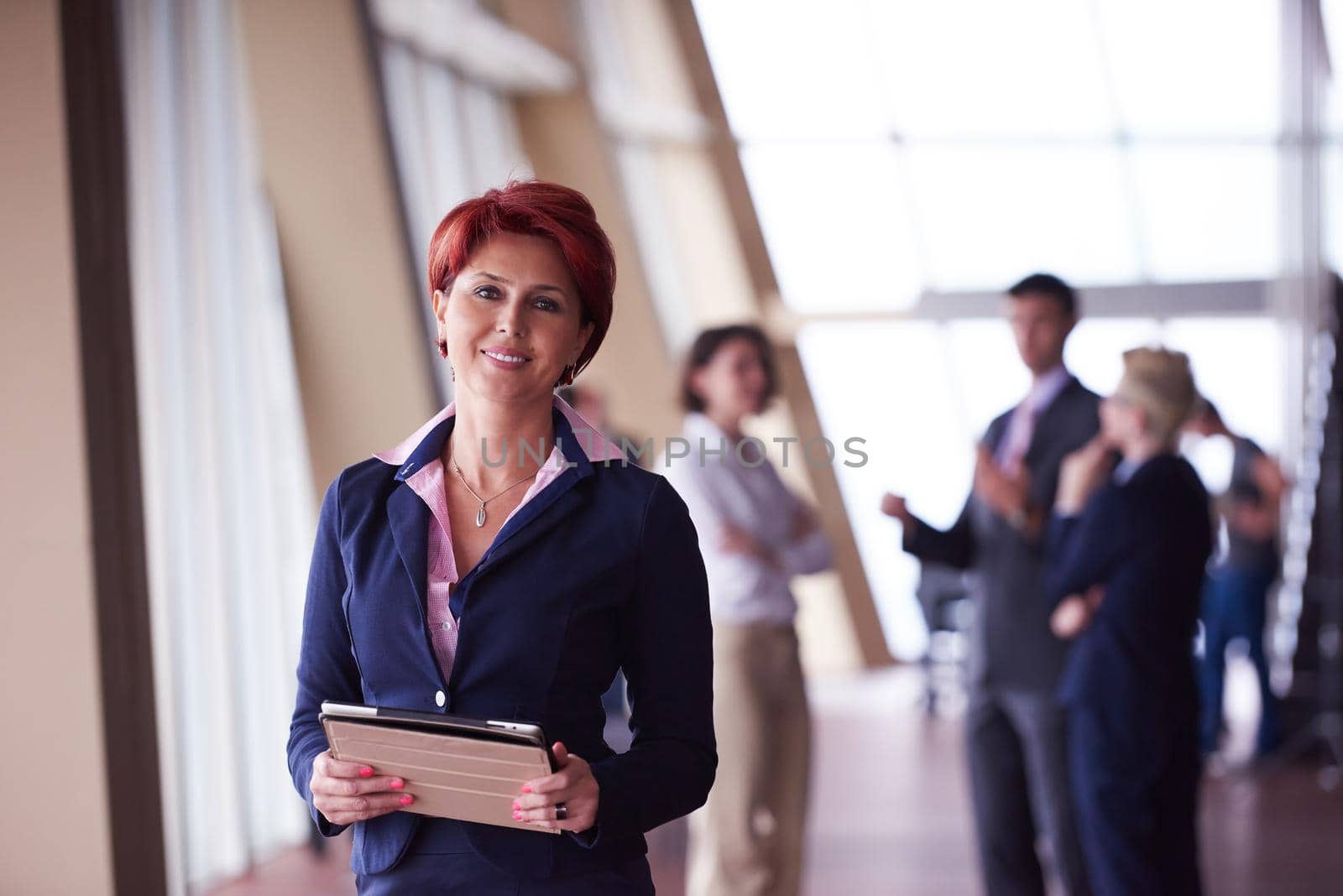 business woman  at office with tablet  in front  as team leader by dotshock